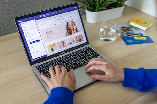 Free Biurko z laptopem, na którym otwarty jest edytor graficzny sklepu internetowego na platformie Shoper Stock Photo