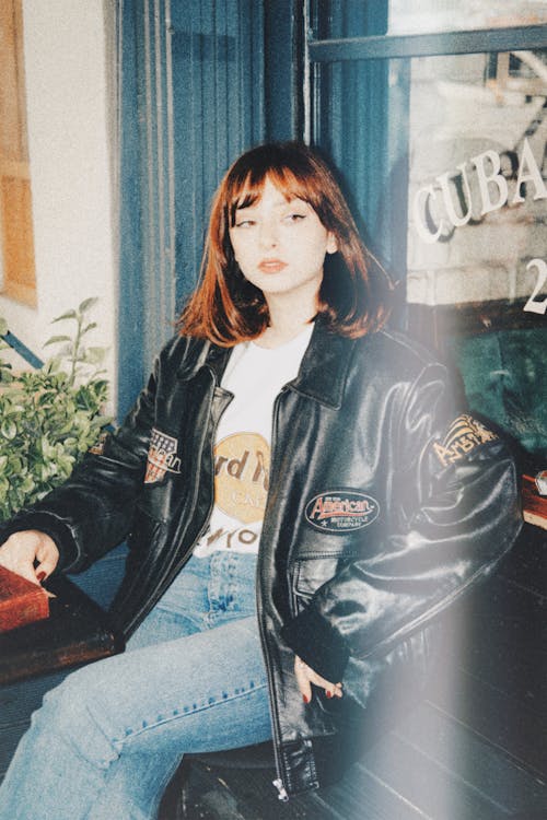 Free Girl in Vintage Leather Jacket Sitting on Bench Stock Photo
