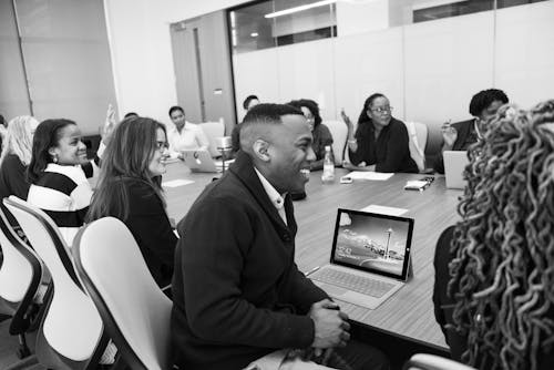 Free Group of People Sitting in Conference Table Laughing Stock Photo