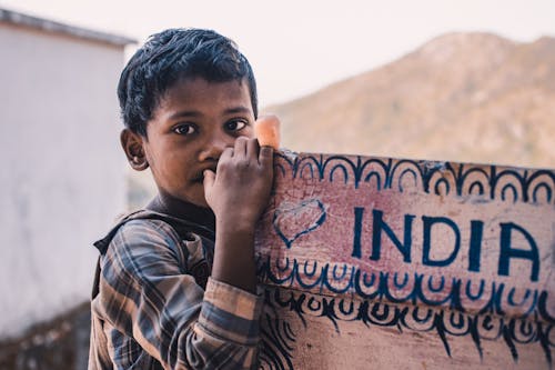 Free Close-Up Photography Of A Boy Near A Signboard Stock Photo