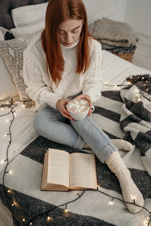 Free Woman Wearing Knitted Sweater Holding a Cup Stock Photo