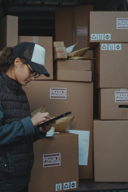 Free Woman in Black Jacket Holding Black Tablet Computer Stock Photo